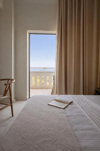 a bedroom with a bed and a large window at Regina Hotel in Kissamos