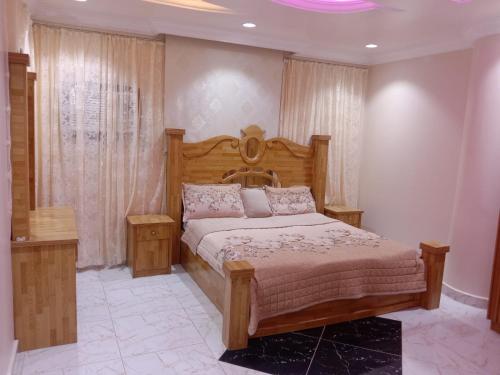 ein Schlafzimmer mit einem Holzbett in einem Zimmer in der Unterkunft أبراج وطني in Al Bahah
