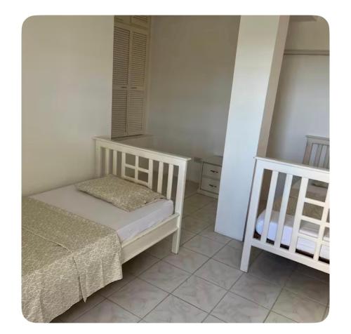 une petite chambre avec un lit et un berceau dans l'établissement Sunset Bliss, à Castries
