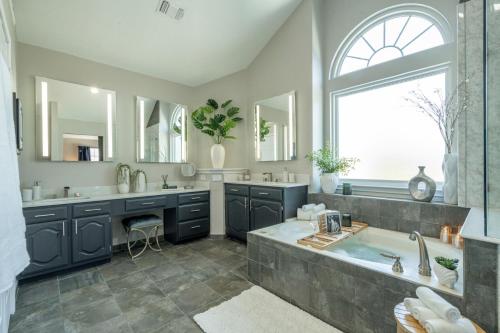 a bathroom with a large tub and a sink at Stylish Oasis Modern Living in Allen