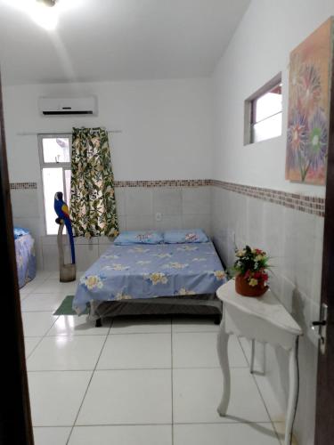 a bedroom with a bed and a table in it at Bio natura in Marechal Deodoro