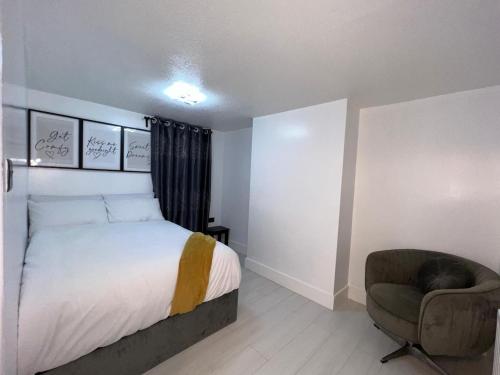a small bedroom with a bed and a chair at Intimate Hot Tub Pad in Swanscombe