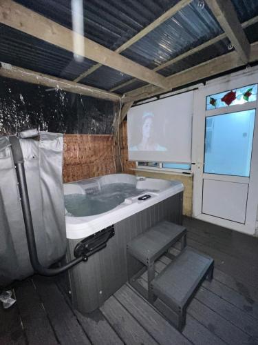 a bathroom with a bath tub and a screen at Intimate Hot Tub Pad in Swanscombe