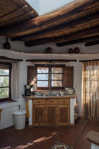 a kitchen with a sink and a window at Casa Walhalla & Cortijo El Páramo in Pampaneira