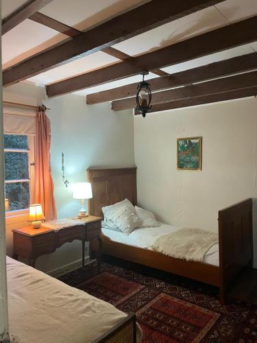 a bedroom with two beds and a table and a window at Casa Krampus Hospedaje y Cervecería in Valdivia