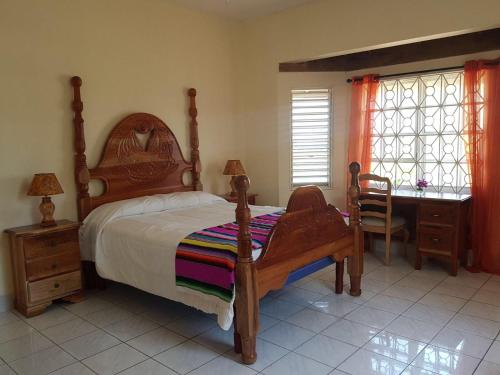 a bedroom with a bed and a desk and windows at Montego Bay Sea View Guesthouse in Montego Bay