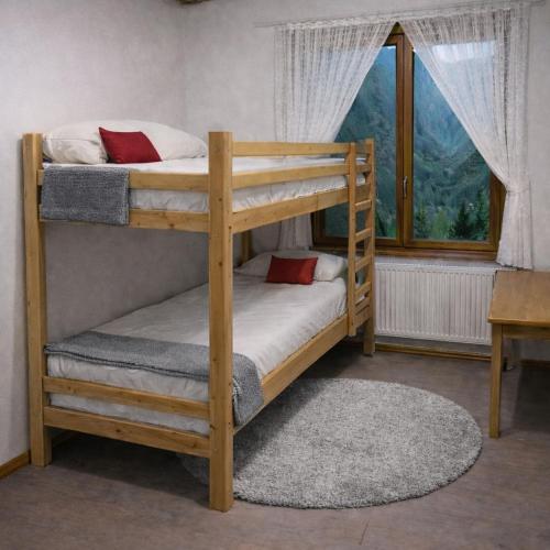 a couple of bunk beds in a room with a window at LES TOURISTES in Le Chatelard