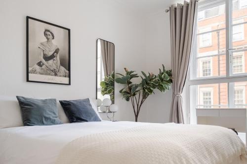a bedroom with a white bed and a window at LONDONERS - Harley Street Serviced Apartments in London