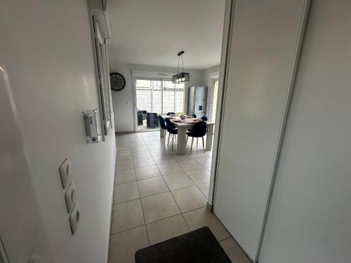 a hallway leading to a dining room with a table at Maison individuelle parking privé et gratuit in Sainte-Savine