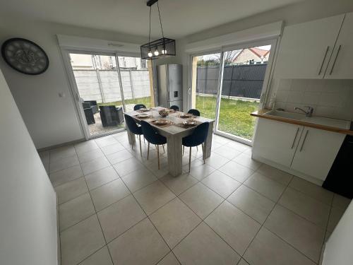 a dining room with a table and chairs in a kitchen at Maison individuelle parking privé et gratuit in Sainte-Savine