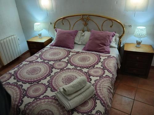 a bedroom with a large bed with purple pillows at Apartamento San Mateo 1 in Cuenca