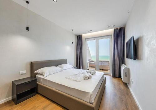 a bedroom with a large bed and a large window at The Seaview Jacuzzi Suite by PS in Golem