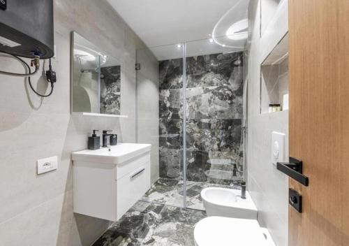 a bathroom with a toilet and a sink and a shower at The Seaview Jacuzzi Suite by PS in Golem