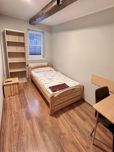 a small room with a bed and a desk at Pension Am Pilgerbach in Baunatal