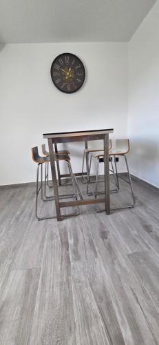 a table with chairs and a clock on a wall at casa stadio2 in Leverkusen