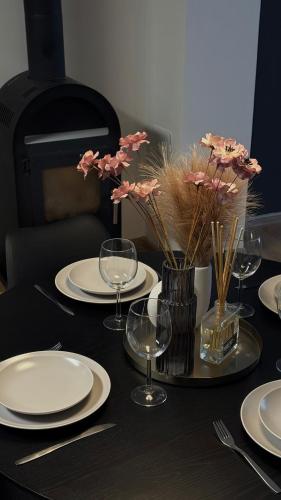 a table with plates and glasses and flowers on it at Apartmán Jungmannka in Bruntál