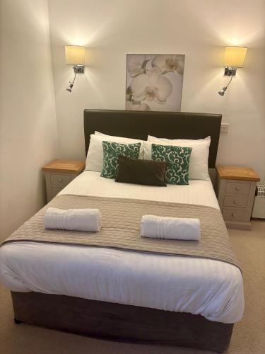 a bedroom with a large bed with two pillows at The Milking Parlour in Aberystwyth