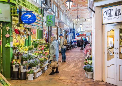a group of people walking through a flower market at Oxford, St Clements, 2-Bed, Minutes to Centre with Private Garden Courtyard in Oxford