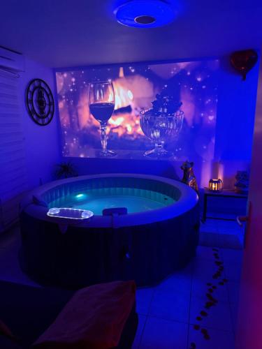 a room with a tub with a glass of wine at Suite Eden Spa, Appart'hôtel bien être , Patio de standing barbecue - TV XL CinéSport, Lit Q-Size, Wifi, P-Gratuit en Résidence in Avion