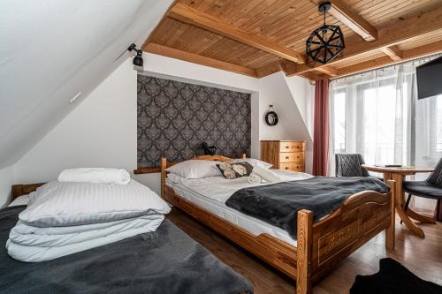 a bedroom with two beds and a table with a chair at Willa u Baranów 2 in Zakopane