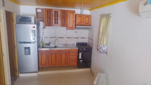 a kitchen with wooden cabinets and a white refrigerator at Cabaña Mailin II in Uspallata