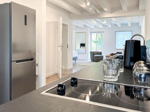 a kitchen with a stainless steel refrigerator and a sink at Gutshaus am Rhein in Düsseldorf