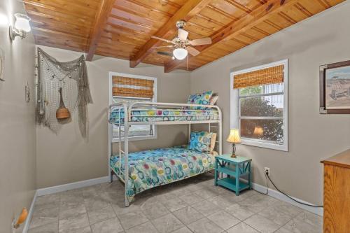 a bedroom with a bunk bed and a ceiling fan at Pool, Blocks away from Beach, Dog friendly in Oak Island
