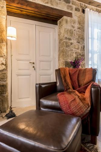 a living room with a leather couch and a table at İda Blue Adatepe in Kucukkuyu