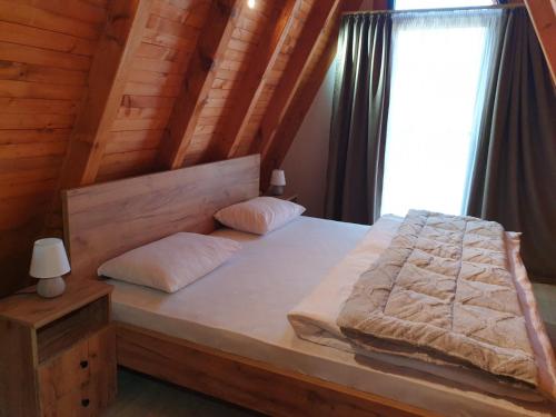 a bedroom with a bed in a wooden house at Kozara Resort in Gornji Podgradci