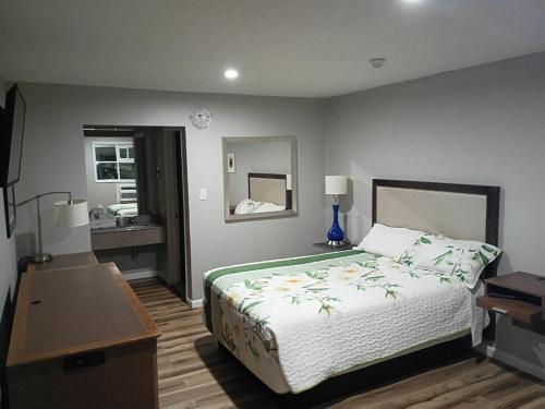a bedroom with a bed and a desk and a sink at Bel Air Motor Lodge in Maple Shade