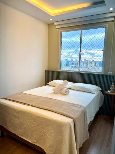 a bedroom with a large bed with a window at Solar Aruana, Aracaju, Aeroporto, Orla de Atalaia e Praia in Aracaju