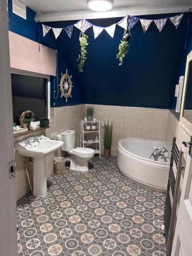 a bathroom with a tub and a toilet and a sink at Kraken Cottage in Bridlington