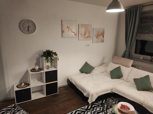 a bedroom with a bed and a clock on the wall at Apartment For You in Hameln