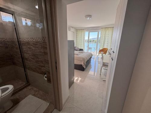 a bedroom with a bed and a bathroom with a shower at Apartman studio BMB 1 in Bukorovac