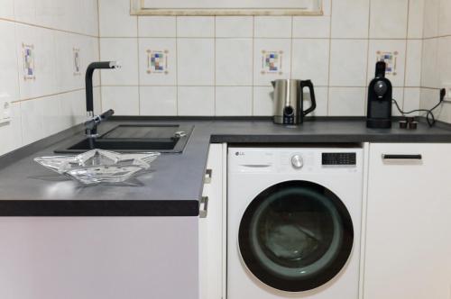 eine Küche mit Waschmaschine und Spüle in der Unterkunft Bronsliving in Schleiden