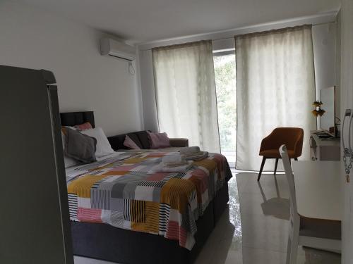 a bedroom with a bed and a chair and a window at Apartman studio BMB 1 in Bukorovac
