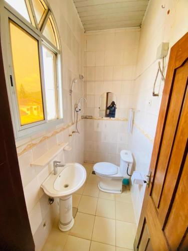 un bagno con lavandino, WC e finestra di sidof a Yaoundé