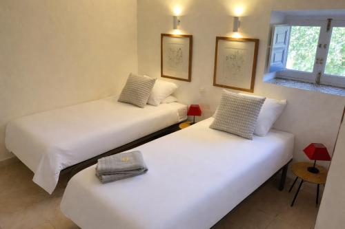 two beds in a room with white sheets at Casa Mariscal Polopos in Polopos