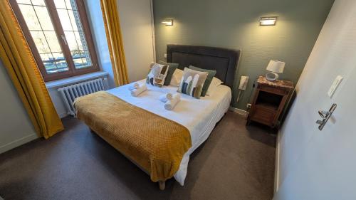 a bedroom with a bed with two stuffed animals on it at Hôtel Restaurant du Plomb du Cantal in Murat
