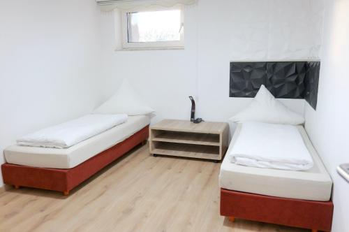 ein Zimmer mit zwei Betten und einem Tisch darin in der Unterkunft Bronsliving in Schleiden