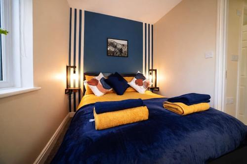 a bedroom with a large blue bed with yellow pillows at Preston Central in Preston