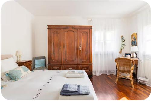 a bedroom with a large bed and a wooden cabinet at Eucalipto in Sestri Levante