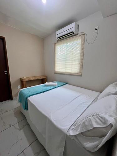 a bedroom with a bed with a air conditioner on the wall at Suíte Peroba em Maragogi in Maragogi