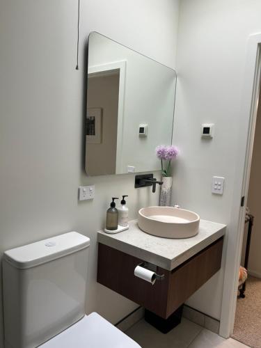 a white bathroom with a sink and a mirror at Charlie Browns Clyde Studio in Clyde