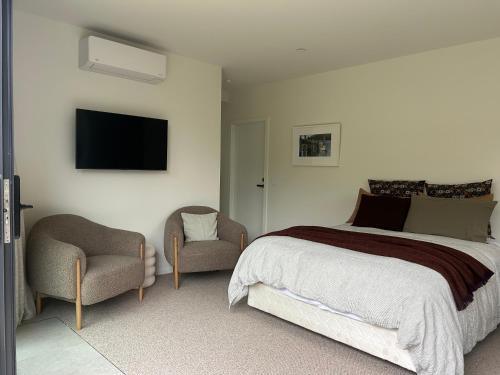 a bedroom with a bed and a chair and a tv at Charlie Browns Clyde Studio in Clyde