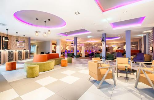 a lobby with colorful chairs and tables at Leonardo Hotel Wolfsburg City Center in Wolfsburg