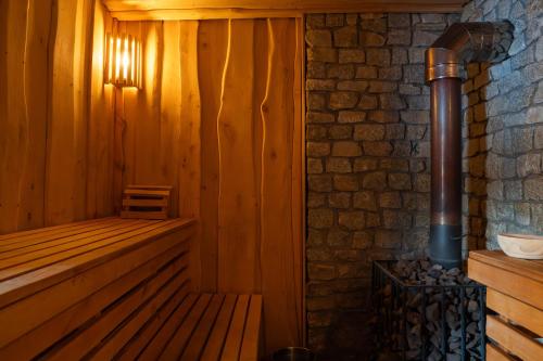 a wooden sauna with a heater and a brick wall at Siedlisko Gruszeczki in Gruszki