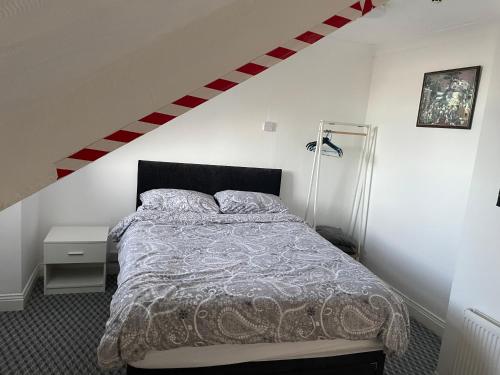 a bedroom with a bed and a staircase at Azalea apartments top floor in Sunderland