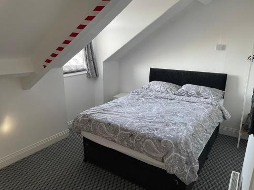 a bedroom with a bed in a white room at Azalea apartments top floor in Sunderland