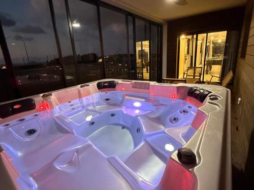 a jacuzzi tub in a room with a window at מתחם שמיים ותכלת נתניה in Netanya